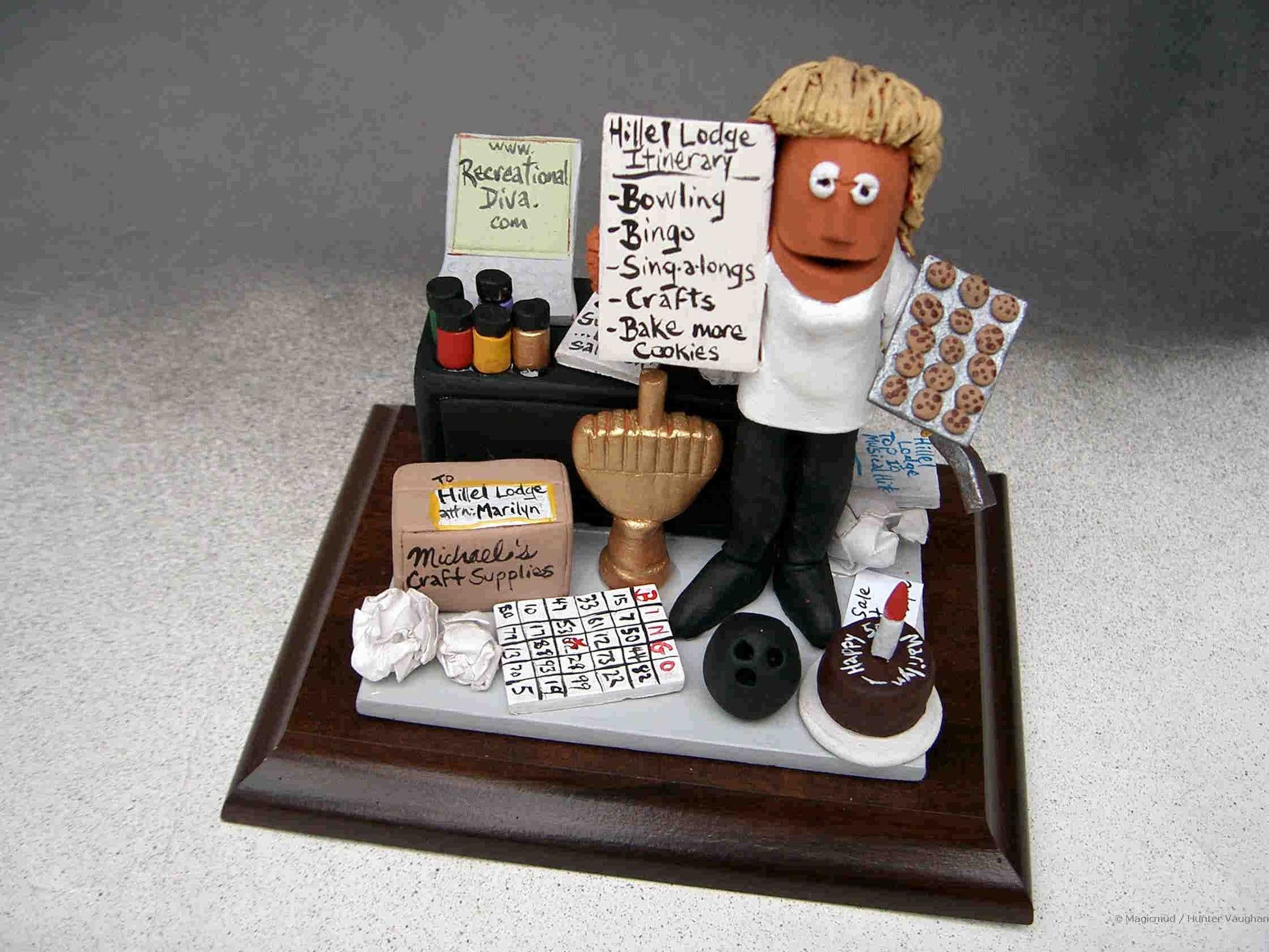 Clay caricature of person who plans the activities, crafts,bowling and more at a seniors home